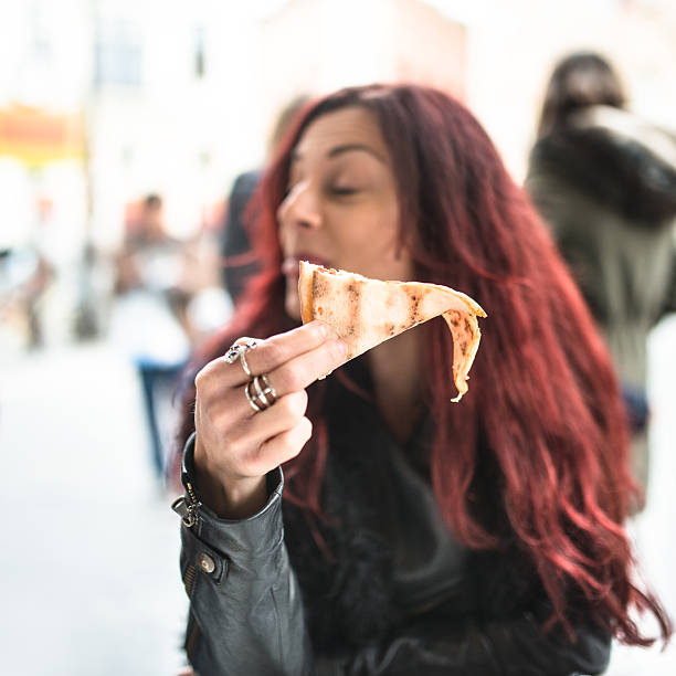 istock woman eating a pizza at restaurant 509479912