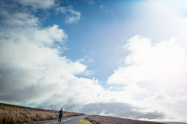 istock Man running along an open Country road 509479996
