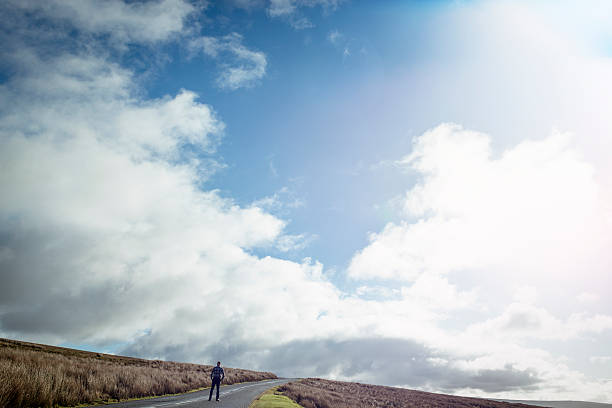 istock Man stood on an open Country road 509480120