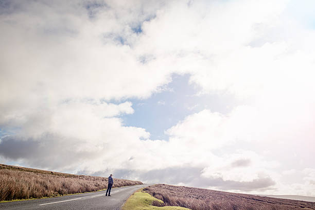 istock Man stood on an open Country road 509480324