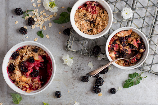 Blackberry and apple crumble dessert on vintage background, selective focus