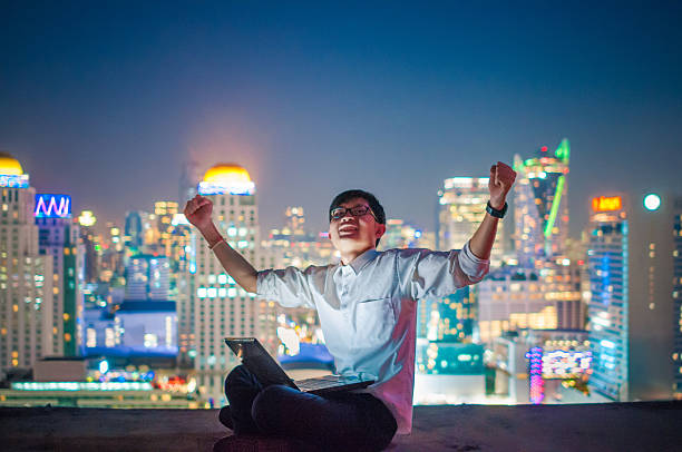 istock Businessman using a laptop on the rooftop of a skyscraper 509480828