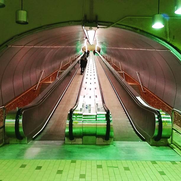 Urban Green Retro Underground Metro Tunnel Escalators Montreal Canada This is a square, color, royalty free stock photograph of a green underground tunnel with escalators in urban Montreal, Quebec Canada. Photographed with a Samsung Galaxy S5. montreal underground city stock pictures, royalty-free photos & images