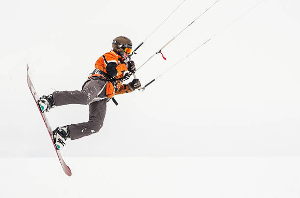 Snowboarder riding a kite stock photo