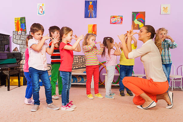 istock Kids repeat after teacher gesture in class 509481554