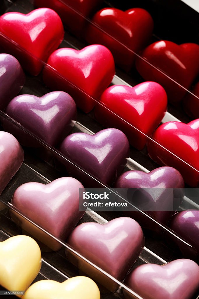 Box of chocolate hearts Black opened box with chocolate multicolored hearts, close up. St. Valentine's Day Concept. Art Stock Photo