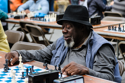 New York, USA - September 20, 2014: Old man playing Chess in Central Park