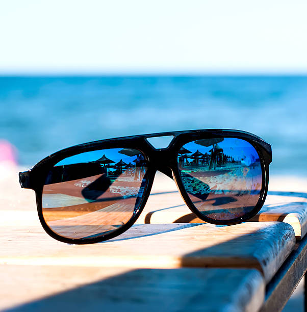 istock sunglasses lie on a beach on sand 509485414