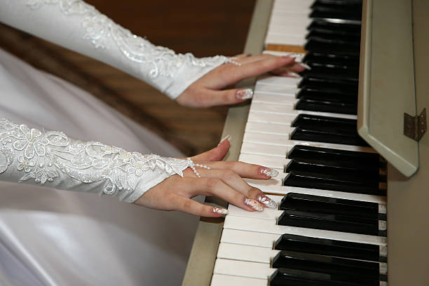 istock bride plays the piano closeup 509486200