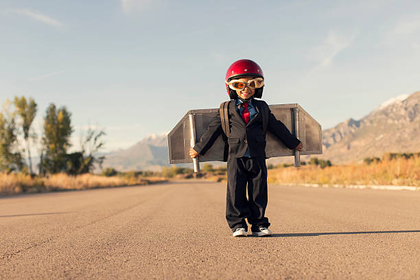jeune garçon portant costume d'affaires et vol jet pack - taking off business creativity adventure photos et images de collection