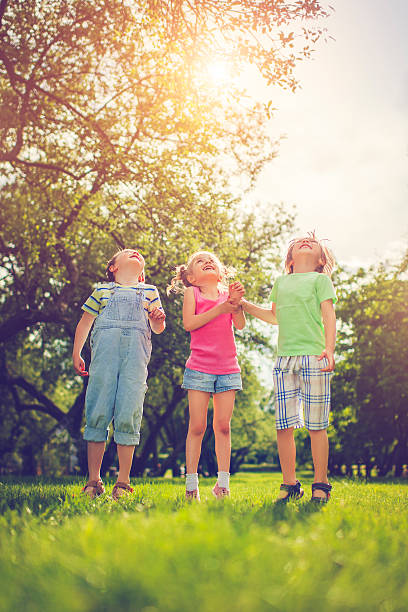 tres niños felices en verano - child laughing blond hair three people fotografías e imágenes de stock