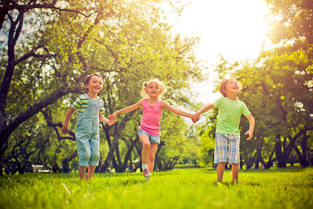 tres niños felices en verano - child laughing blond hair three people fotografías e imágenes de stock