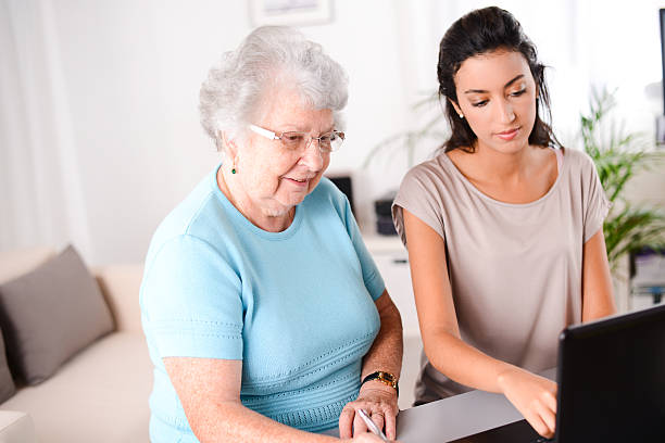 istock young woman helping elderly person with computer internet search email 509489005