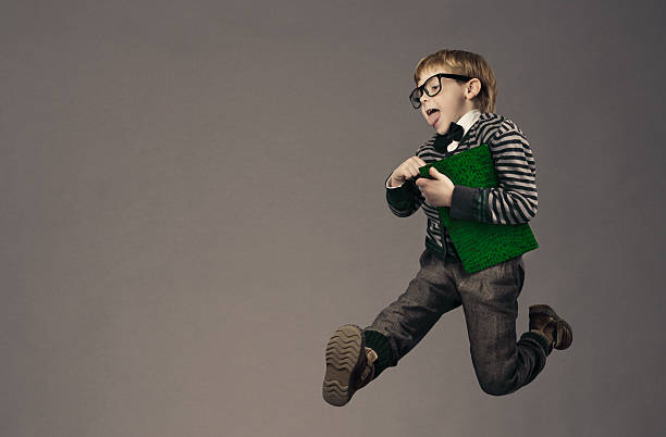 istock child running back to school, funny kid, jumping smart schoolboy 509489235