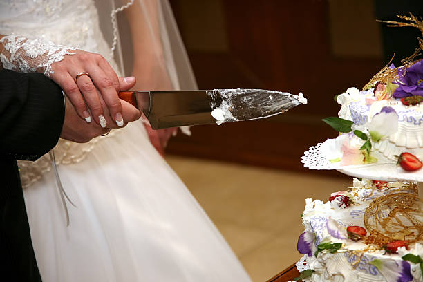 istock bride and groom cut the wedding cake closeup 509489988