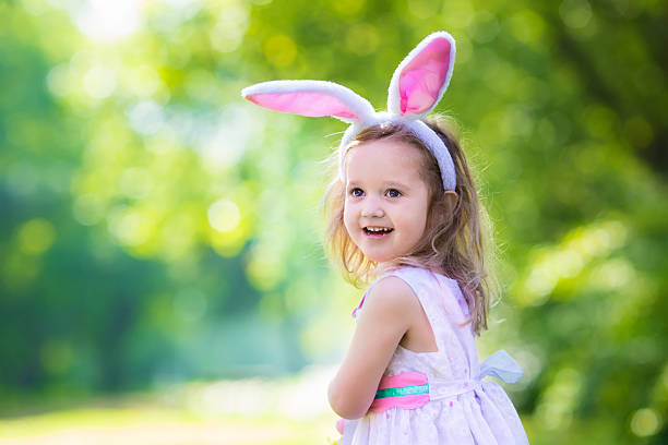 маленькая девочка с белой доской для пасхального приветствия - child easter flower little girls стоковые фото и изображения