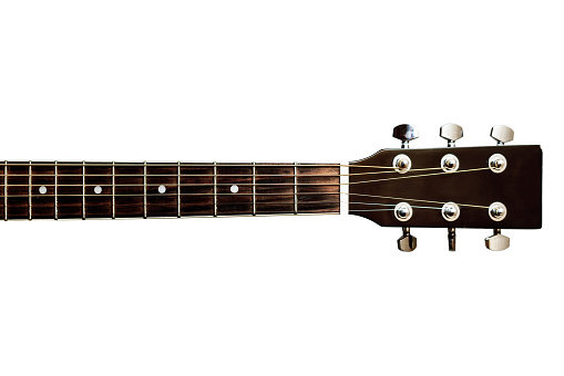 Extreme close up view of steel strings and fretboard of an acoustic guitar.