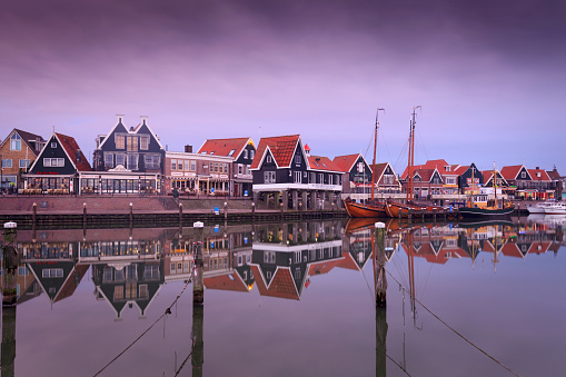 Volendam, Netherlands - October 18, 2015: traditional houses along the harbour of the Dutch fishing village Volendam in the early morning. Volendam is a popular tourist destination in the Netherlands, wellknown for its fishing boats and the traditional costume still worn by some residents