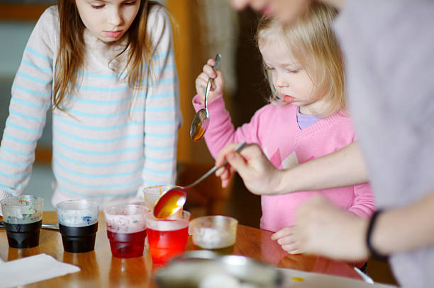 istock Young mother and her two daughters painting Easter eggs 509500574