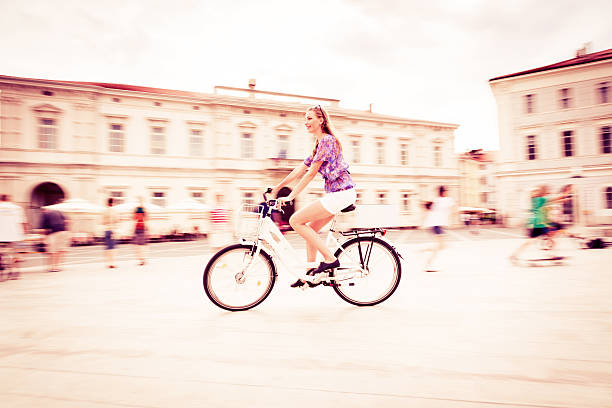 istock young woman cycling through town square 509511423