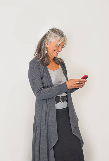 istock Beautiful middle aged woman texting on phone against white background 509511461
