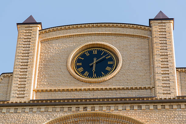 Clocks in retro style on the building of yellow brick