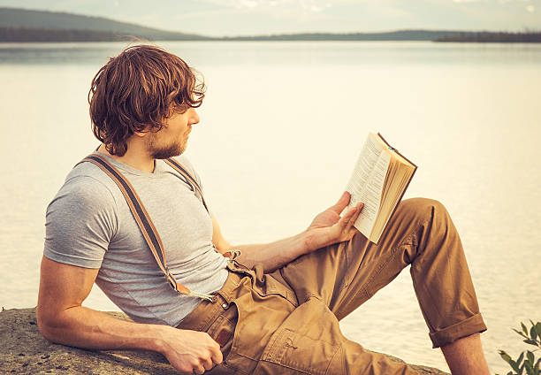 istock Young Man reading book outdoor Lifestyle 509512363
