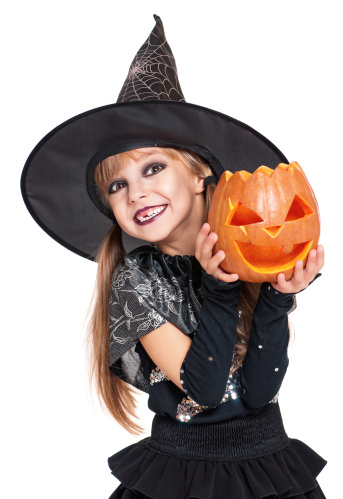 Portrait of little girl in black hat with pumpkin isolated on white background