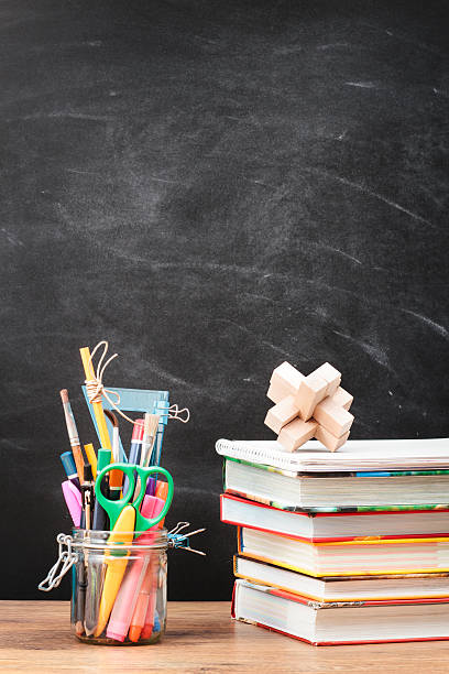 istock School accessories on desktop. Blank blackboard in the background 509513923