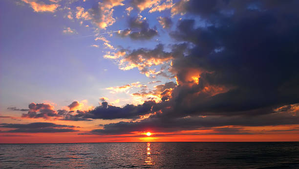 istock Dark yellow-red evening sunset sky with clouds over calm sea 509514889
