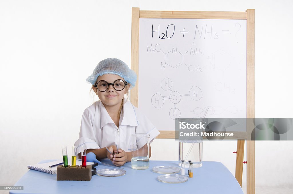 Scientist chemist at table in the laboratory Chemist girl sitting at the table with the reagents in chemistry class and puts experiments Baby - Human Age Stock Photo