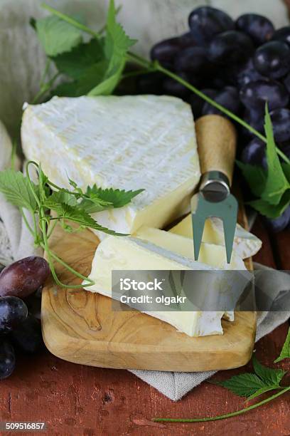 Soft Brie Cheese With Sweet Grapes On A Wooden Board Stock Photo - Download Image Now