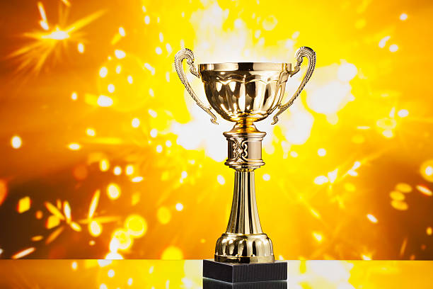 istock gold cup trophy against shiny sparks background 509530380