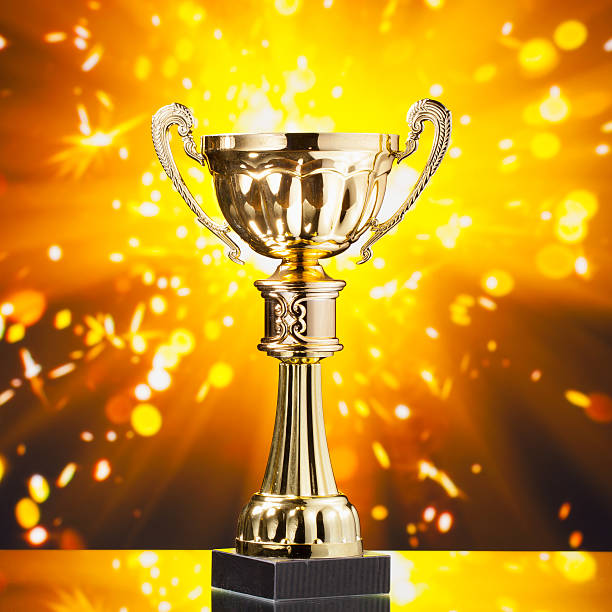 istock gold cup trophy against shiny sparks background 509530404