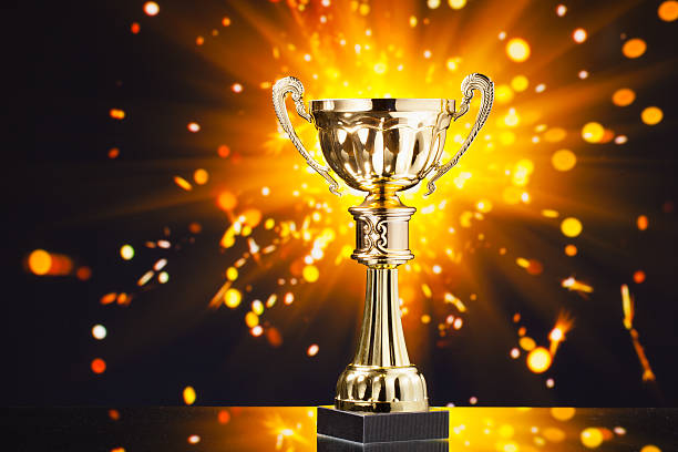 istock gold cup trophy against shiny sparks background 509530428