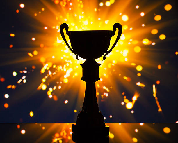 istock cup trophy silhouette against shiny sparks background 509530482