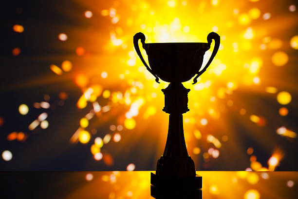istock cup trophy silhouette against shiny sparks background 509530498