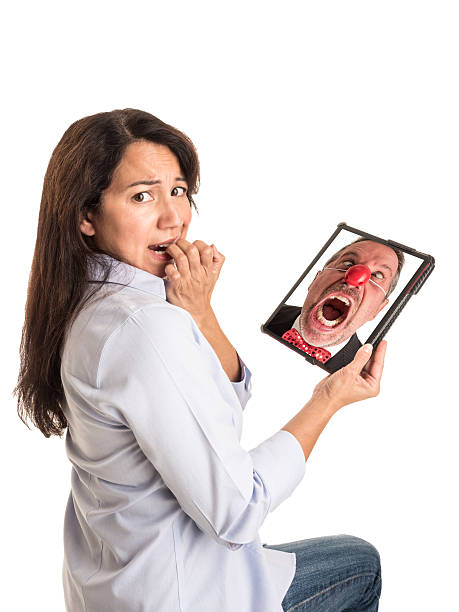 Young Mixed Race Woman Reacts to Angry Clown on Tablet. stock photo