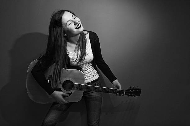 istock Brunette enjoys playing guitar black and white 509533775