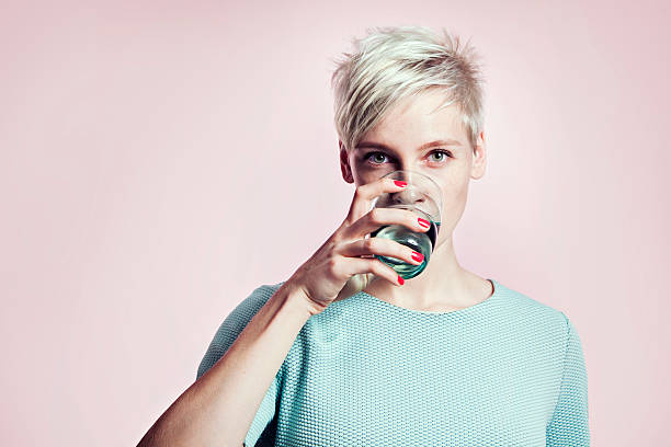portrait de femme blonde avec verre de l'eau, cheveux courts - water women glass healthy eating photos et images de collection