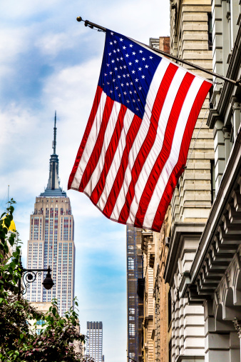 A photograph of the United Stripes Flag with the Empire State Building in the background