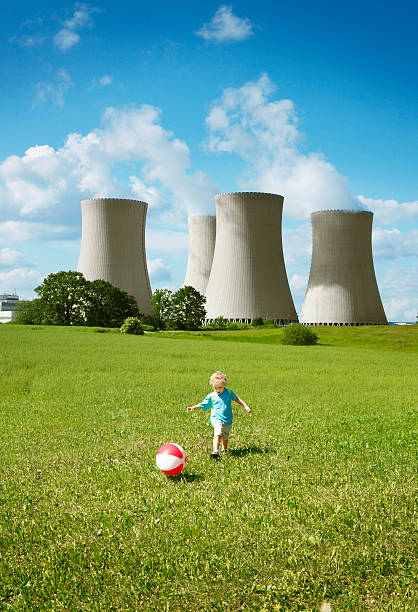 ragazzino giocando vicino alla centrale nucleare - nuclear power station nuclear energy child nuclear reactor foto e immagini stock