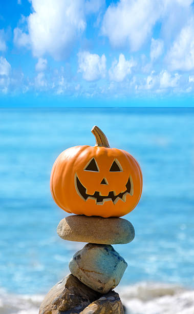 Halloween pumpkin on the beach stock photo