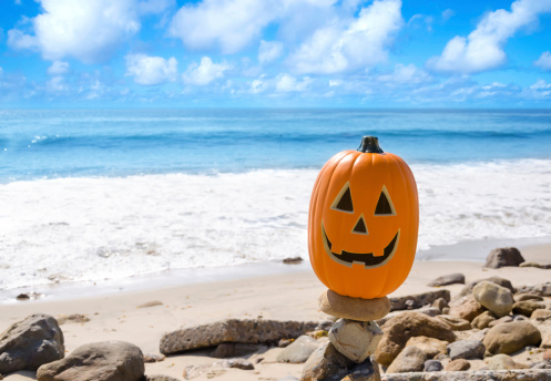 Halloween pumpkin on the beach by ocean