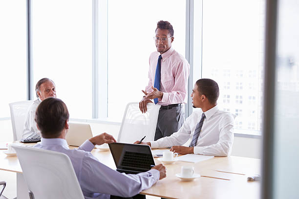 istock Four Businessmen Having Meeting Around Boardroom Table 509540041