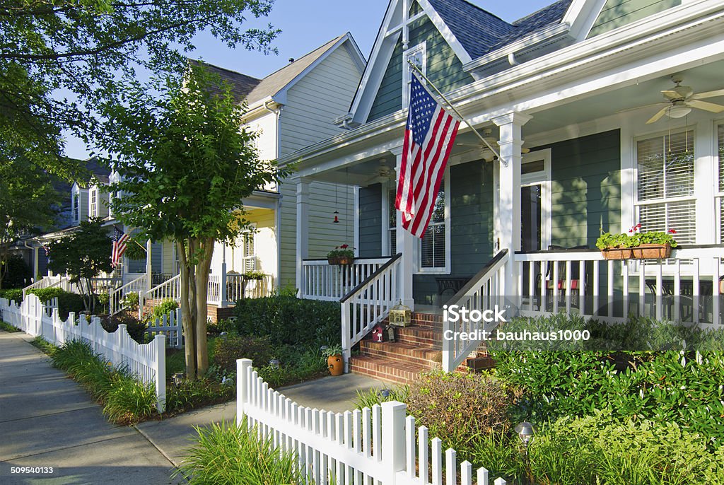 American Dream The American Dream of a house in a nice neighborhood with a white picket fence is captured in this iconic image. American Flag Stock Photo
