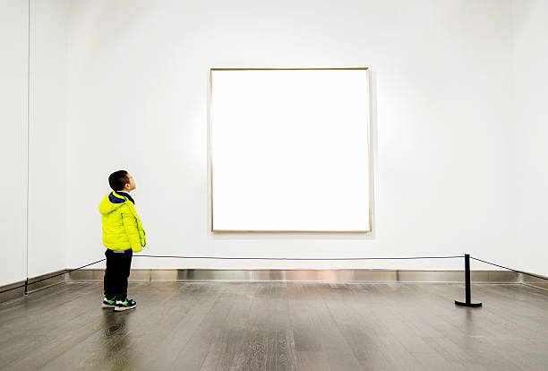 Asian boy looking at artwork Asian boy looking at white frames in an art gallery. child art people contemporary stock pictures, royalty-free photos & images