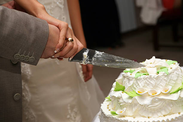 istock bride and groom cut the wedding cake closeup 509541136