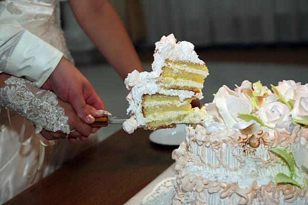 istock bride and groom cut the wedding cake closeup 509541246