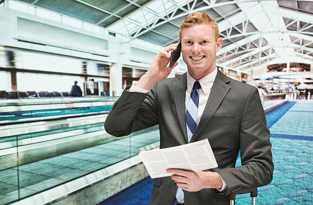 sonriente hombre de negocios con teléfono móvil en el aeropuerto - airport newspaper travel business travel fotografías e imágenes de stock